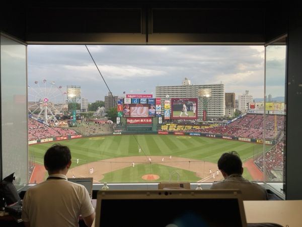 仙台の楽天モバイルパークで翌日の野球中継の準備中アナウンサー陣と試合を見ながらたわいもない会話もしています。メディア制作:百井